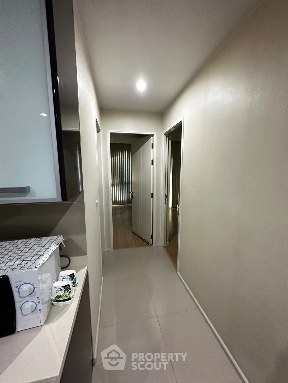 Modern apartment hallway with sleek design and microwave in view