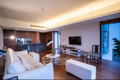 Luxurious modern living room with open kitchen, elegant decor, and ambient lighting.
