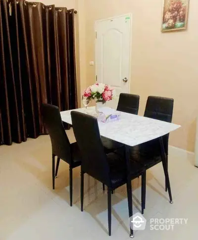 Elegant dining area with marble table and black chairs in cozy apartment