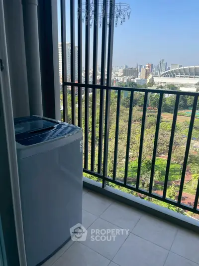 High-rise balcony with washing machine and city park view