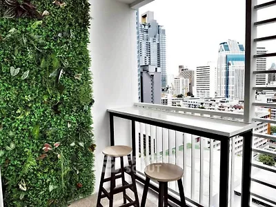 Modern balcony with lush vertical garden and city skyline view, perfect for urban living.