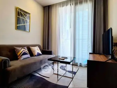 Modern living room with stylish decor and large window offering city views.