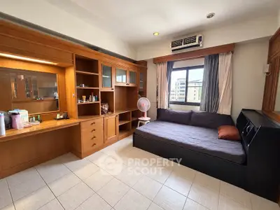 Spacious bedroom with built-in wooden cabinets and large window view