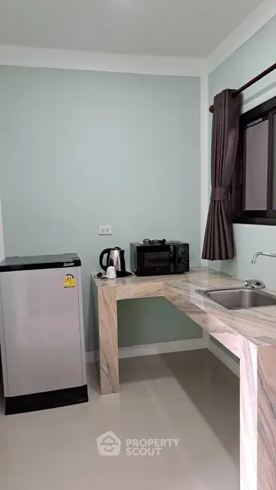 Modern kitchen with sleek marble countertop and compact appliances