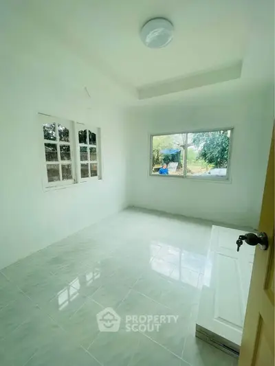 Bright empty room with large windows and tiled floor, perfect for customization.