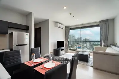 Modern open-plan living room with city view, featuring sleek furniture and a stylish dining area.