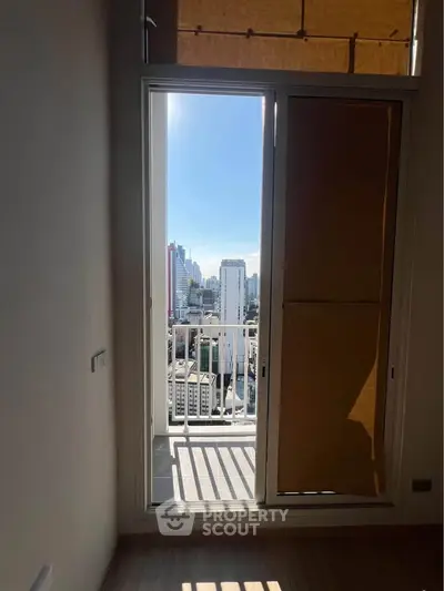 Bright apartment with city view from balcony, featuring large windows and modern design.