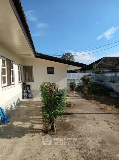 Charming single-story home with spacious outdoor area and lush greenery, perfect for family living.