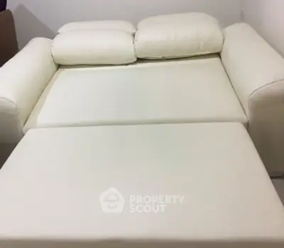 Luxurious white leather sofa bed in modern living room setting.