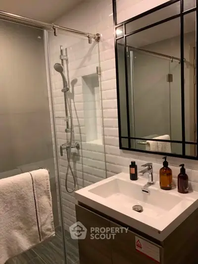 Modern bathroom with glass shower and stylish vanity in contemporary apartment.