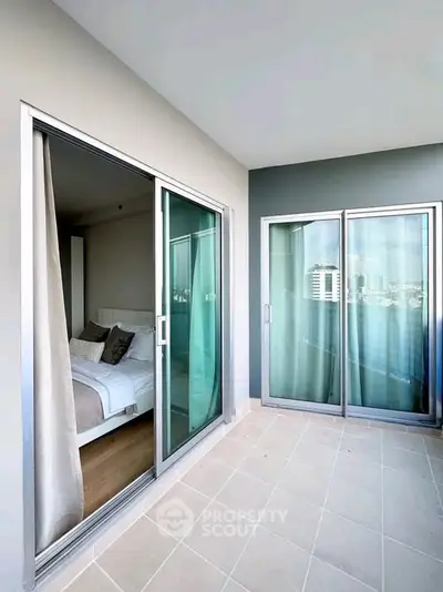 Spacious balcony with sliding glass doors and city view, perfect for relaxation and enjoying the skyline.