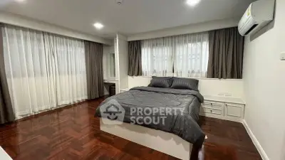 Spacious bedroom with elegant wooden flooring and modern decor