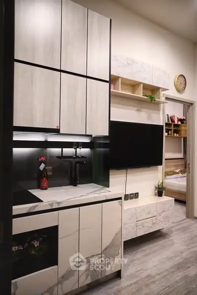 Modern kitchen with sleek cabinetry and integrated TV in stylish apartment