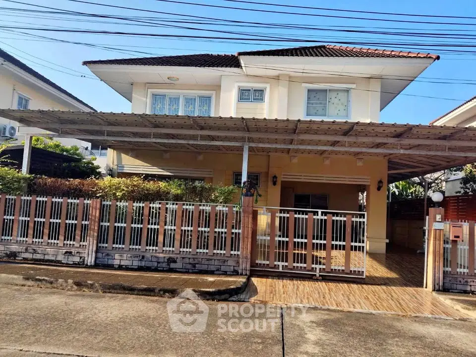 Charming two-story house with covered carport and fenced yard in a serene neighborhood.