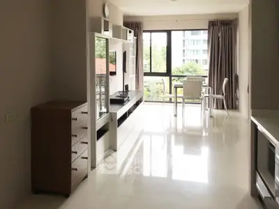 Bright modern living room with large windows and sleek furniture in a high-rise apartment.