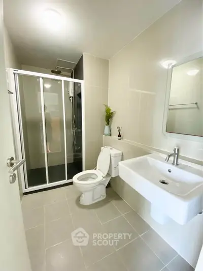 Modern bathroom with sleek shower and elegant fixtures in a contemporary apartment.