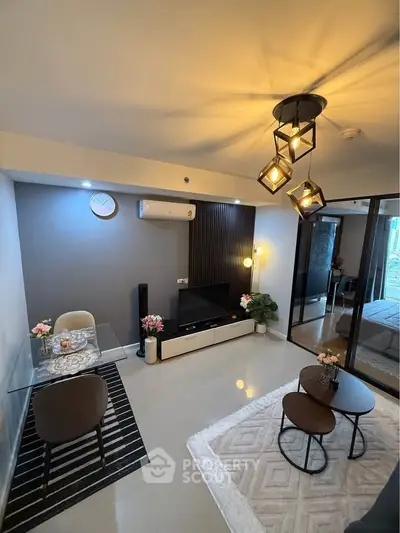 Modern living room with stylish decor, glass dining table, and cozy seating area in a contemporary apartment.