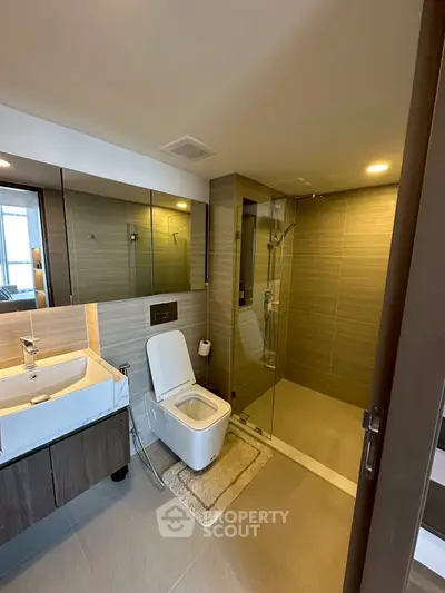 Modern bathroom with glass shower and sleek fixtures in luxury apartment