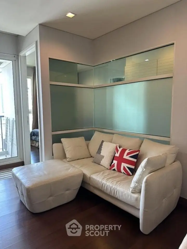 Modern living room with white leather sofa and glass wall accents