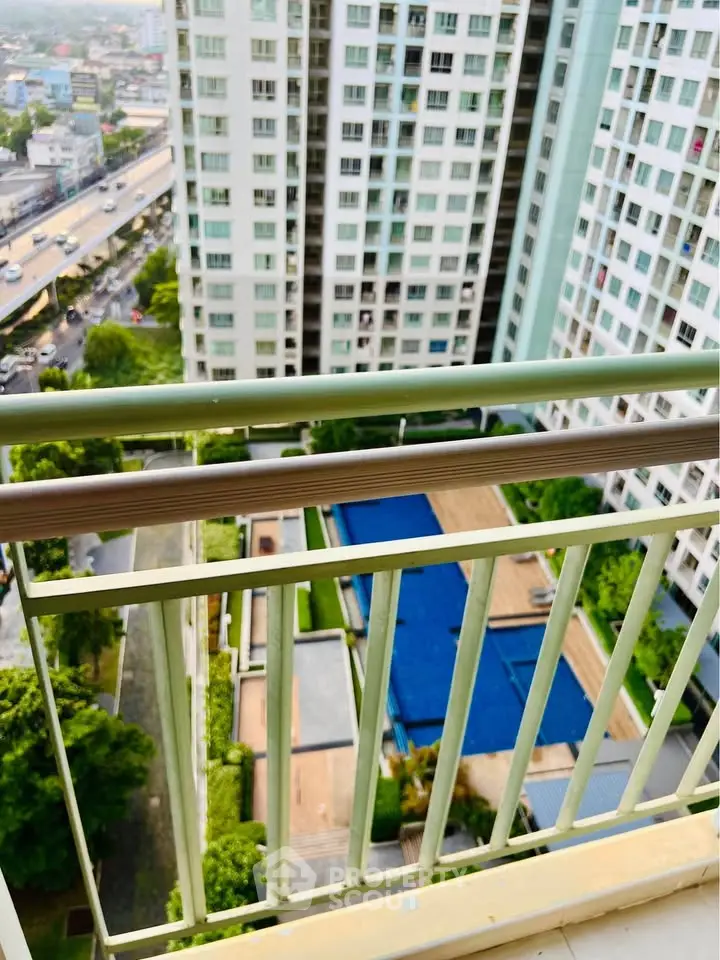 Stunning high-rise view from balcony overlooking pool and cityscape, perfect for urban living.