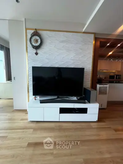 Modern living room with stylish TV setup and elegant kitchen view