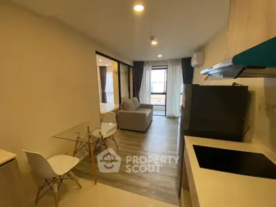 Modern open-plan living room with kitchen and dining area, featuring sleek design and ample natural light.