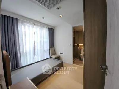 Modern bedroom with large window and en-suite bathroom in a stylish apartment.