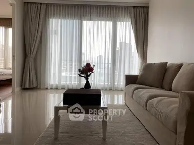Elegant living room with plush sofa and city view through large windows, perfect for urban living.