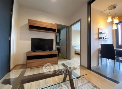 Modern living room with wooden furniture and glass coffee table in a cozy apartment.