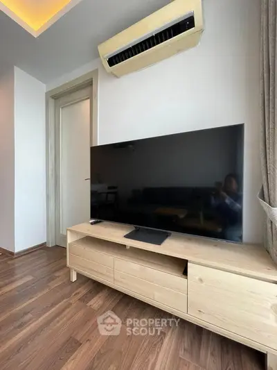 Modern living room with sleek TV and wooden flooring