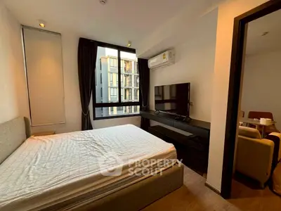 Modern bedroom with large window and TV, featuring a cozy bed and stylish decor.