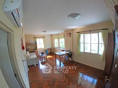 Spacious living room with parquet flooring and natural light