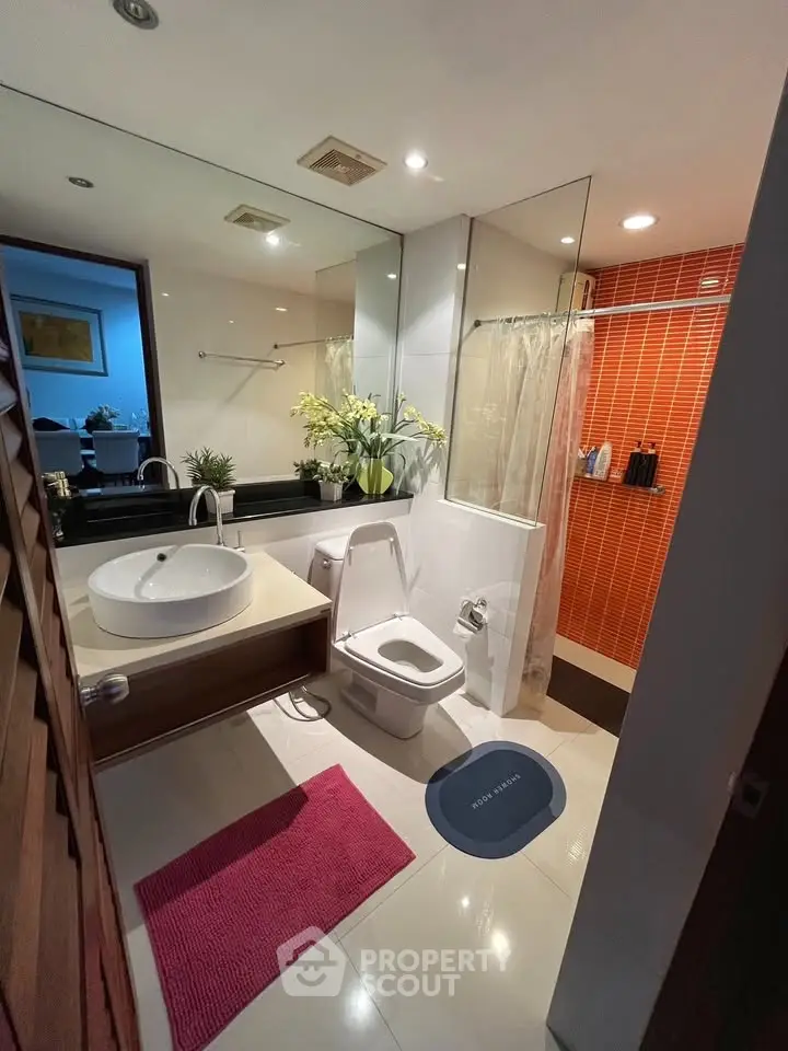 Modern bathroom with stylish fixtures and vibrant red accent wall