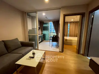 Modern apartment living room with open kitchen and cozy bedroom view
