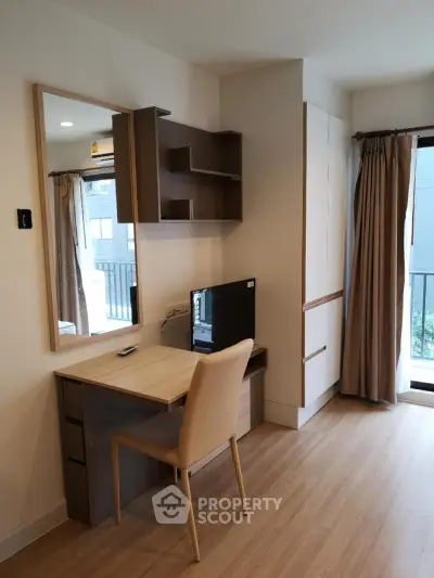 Modern study area with desk, chair, and shelving in a bright apartment.