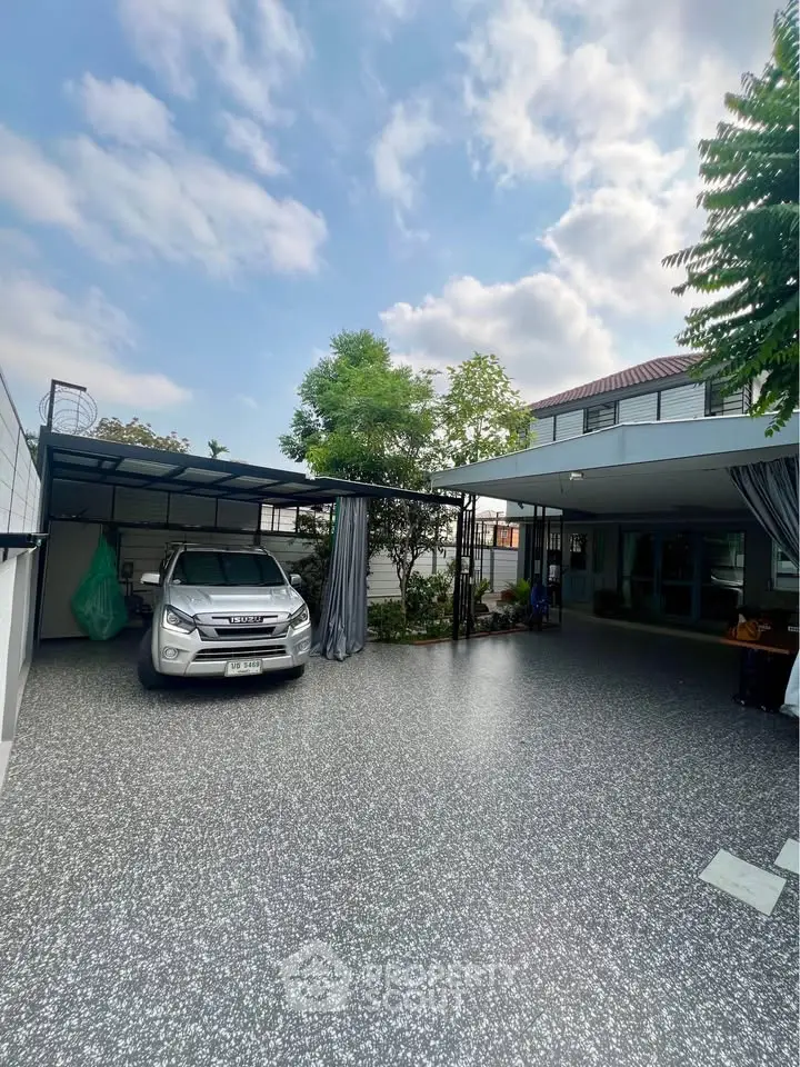Spacious modern home with covered parking and lush greenery, perfect for family living.