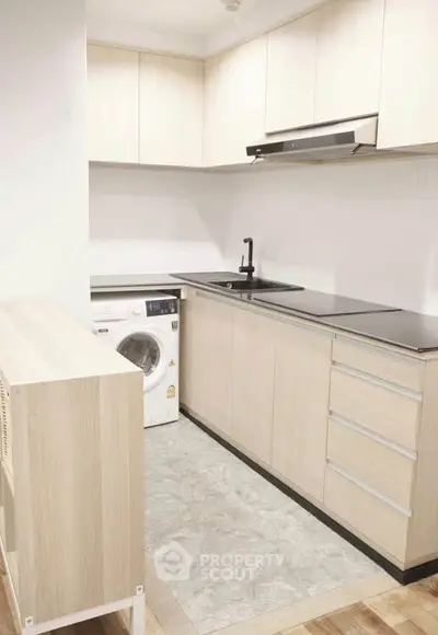 Modern kitchen with sleek cabinetry and built-in washing machine