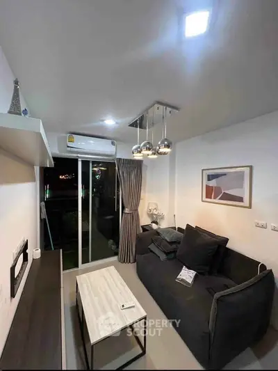 Modern living room with sleek decor and balcony access, featuring stylish lighting and comfortable seating.
