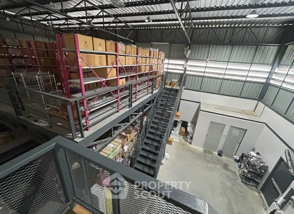 Spacious industrial warehouse with mezzanine storage and modern steel structure.