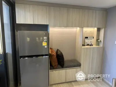 Modern kitchen with sleek fridge and cozy seating area, perfect for stylish living.