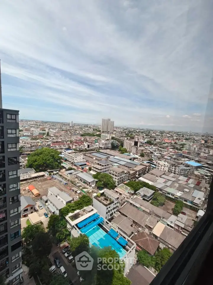 Stunning cityscape view from high-rise building with pool and urban landscape.