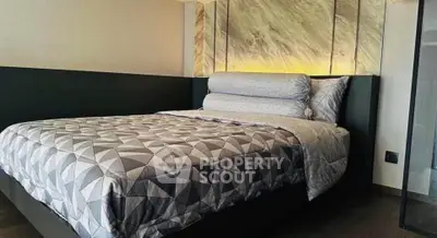 Luxurious bedroom with modern design and elegant lighting, featuring a stylish bed and geometric bedding.