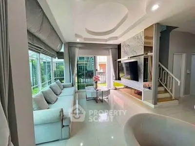 Luxurious modern living room with elegant decor and large windows offering natural light.