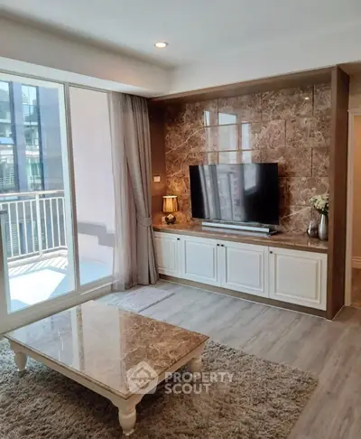 Elegant living room with marble accents and large balcony access in modern apartment.