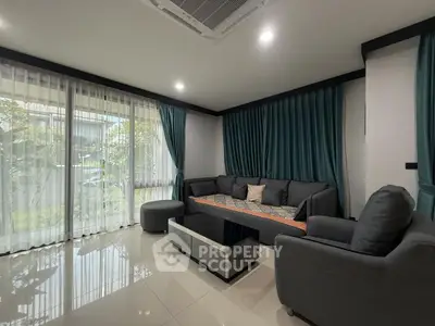 Modern living room with sleek furniture and large windows for natural light.