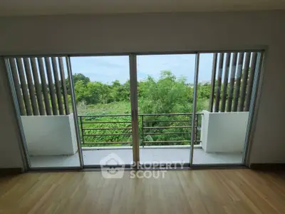 Spacious balcony with lush green view and sliding glass doors