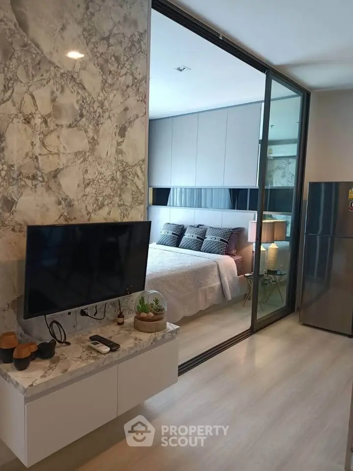 Modern apartment interior with stylish bedroom and open living area featuring marble accents.