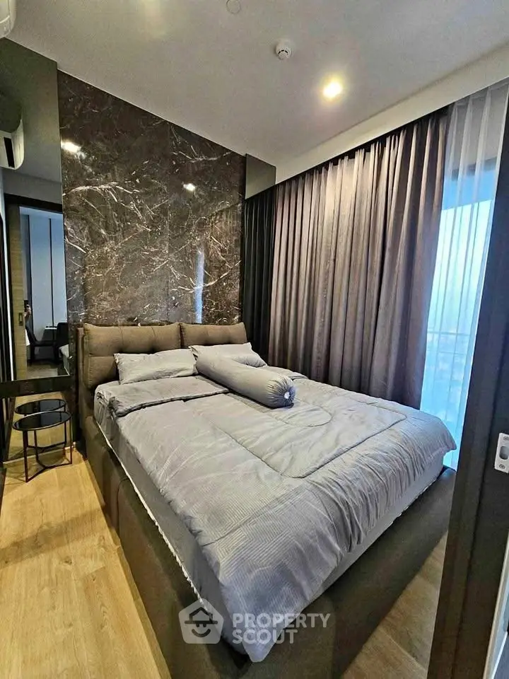Luxurious bedroom with elegant marble accent wall and floor-to-ceiling curtains