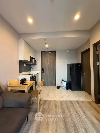 Modern apartment interior with open kitchen and cozy living area, featuring sleek appliances and stylish decor.