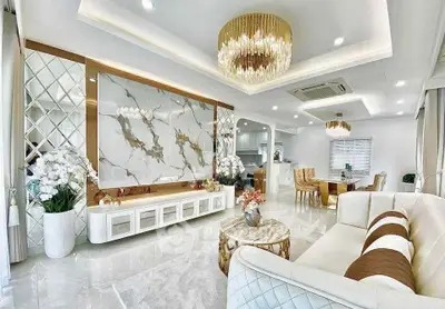 Luxurious living room with elegant decor, marble accents, and modern lighting in a spacious open layout.
